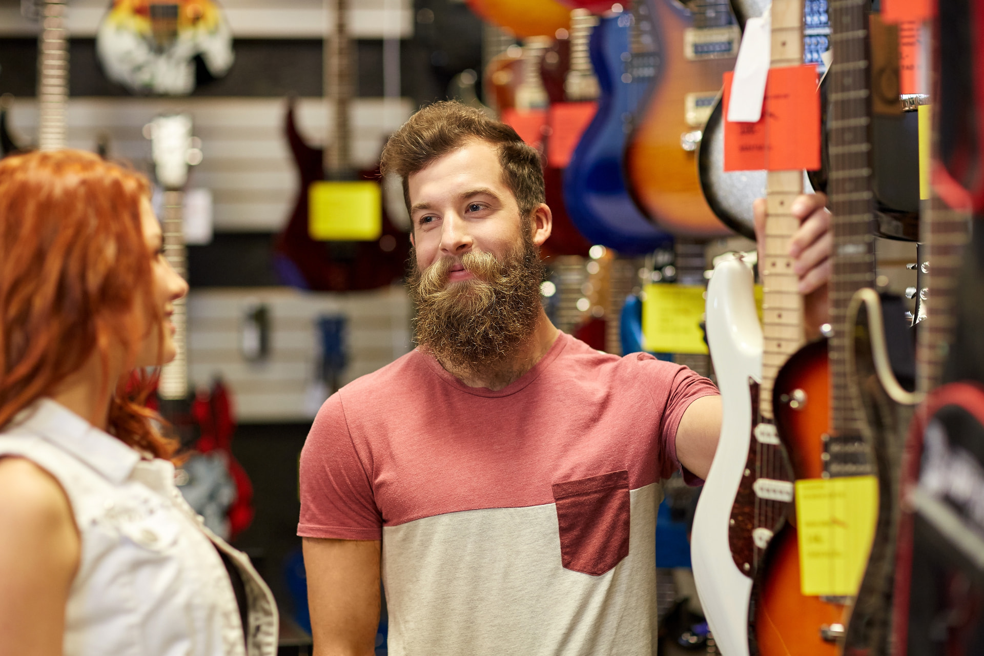 Customers looking at electric guitars in a music store
